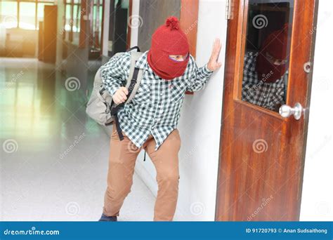 masked burglar escaping after sneaking into the house crime concept