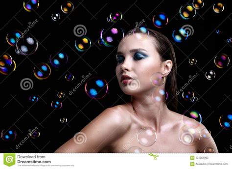 belle jeune femme de brune avec des bulles de savon sur le backgr noir