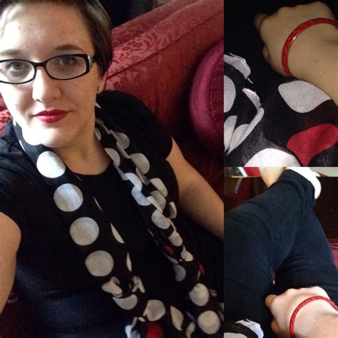A Woman Sitting On A Couch Wearing Glasses And A Polka Dot Scarf