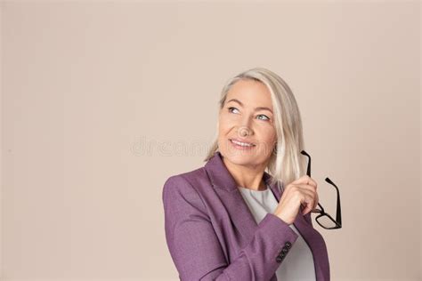 Portrait Of Beautiful Mature Woman With Glasses On Beige Background