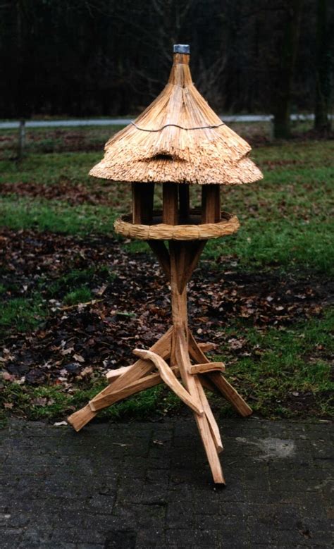 vogelhuisje op een pootmet een rieten dakje bird houses outdoor decor bird feeders