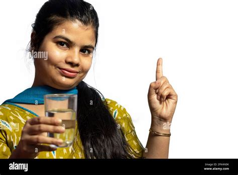 An Indian Asian Woman With Glass Of Water Pointing On White Background