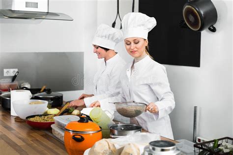 cocineros de sexo femenino que preparan la comida en cocina del