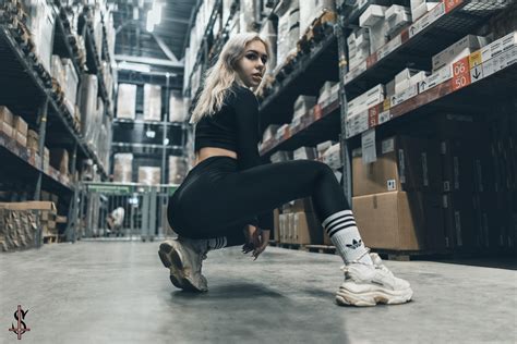 women squatting blonde looking at viewer black clothing white