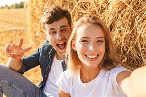 Photo Of Cheerful Couple Man And Woman Taking Selfie While Sitting