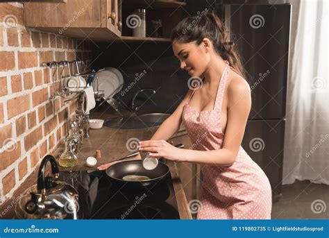 Beautiful Smiling Young Woman In Apron Cooking With Frying Pan Stock