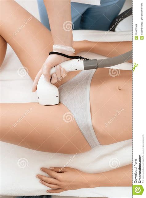 the woman came to the procedure of laser hair removal the doctor processes her bikini area with