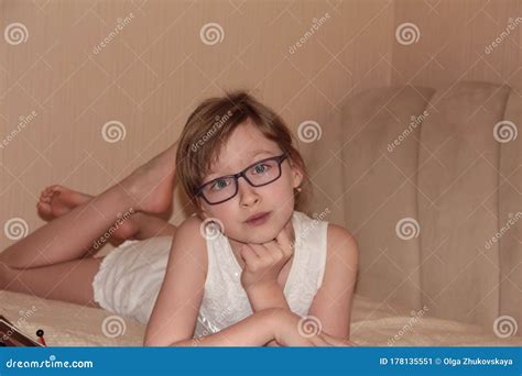 child  glasses  lying   bed  reading  book distance learning stock image