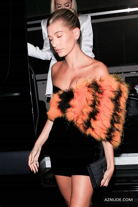 hailey baldwin looking sexy in a black with orange accented dress