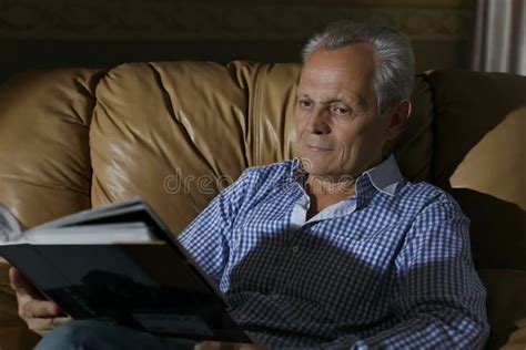 elderly man smiling examines  photo   album stock photo image