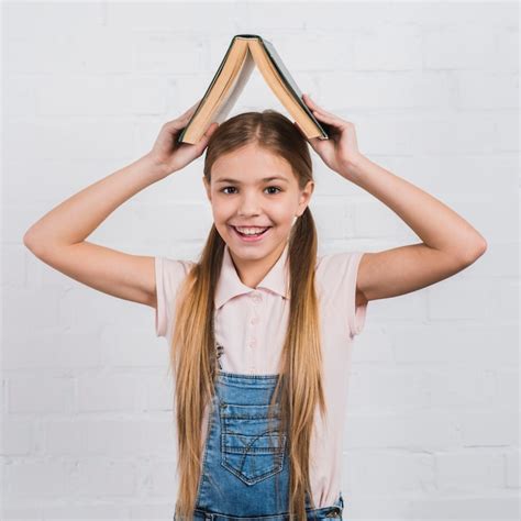 Free Photo Smiling Portrait Of A Girl Holding An Open Book On Her