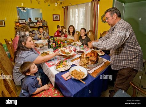hispanic father carves  turkey   thanksgiving dinner stock photo  alamy