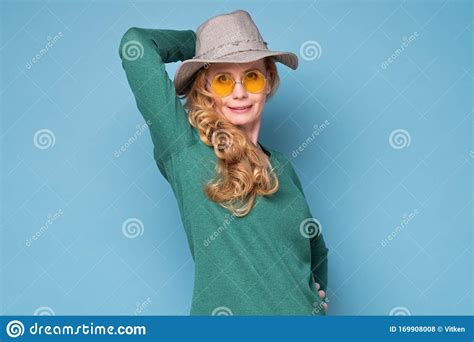Mature Blonde Woman With Hat And Sunglasses Smiling Dreaming About