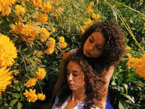 Two Sisters Hugging In A Yellow Flowers By Stocksy Contributor Anna