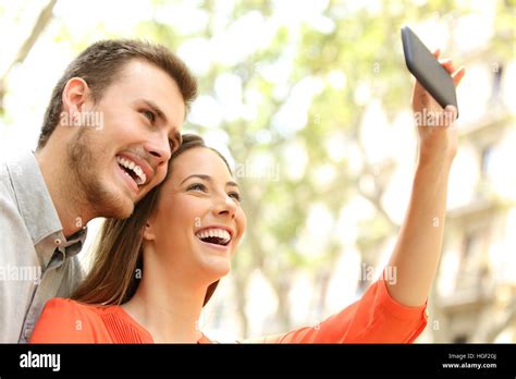 Happy Casual Couple Taking Selfie Or Photographing With A Smart Phone