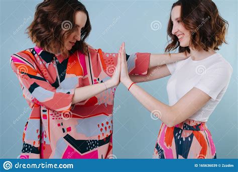 two twin sisters trying to melt the ice in a relationship stock image