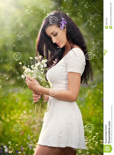 Young Beautiful Brunette Woman Holding A Wild Flowers Bouquet In A