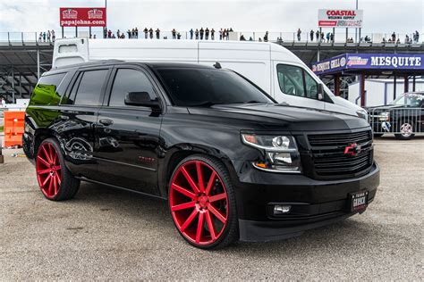 black suv  red rims parked  front   white van