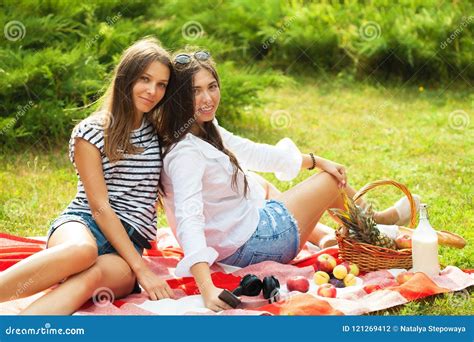 Two Beautiful Young Girls Are Sitting On A Summer Picnic In A Park Copy