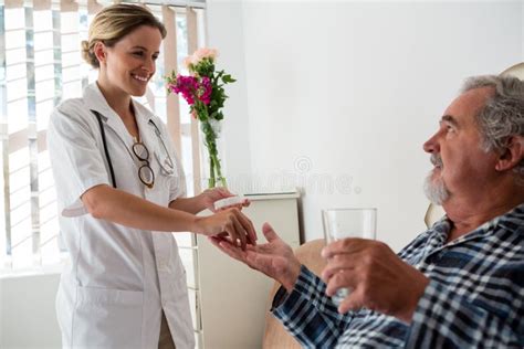 female doctor giving medicines to senior patient stock image image of