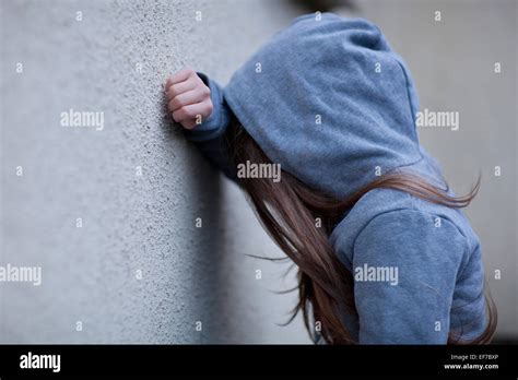 sad girl  hoodie  face hidden leaning   wall  despair stock photo alamy