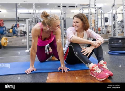 fitness instructor and mature woman at gym female sports instructor