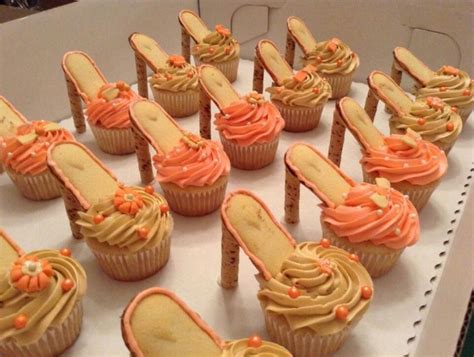 cupcakes with orange frosting and matching shoes on them are displayed