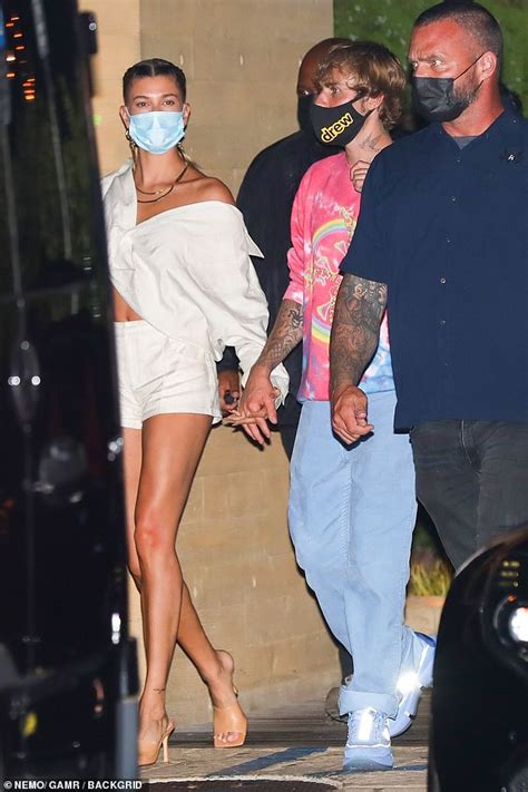 hailey bieber showcases her legs in tan shorts while dining with her