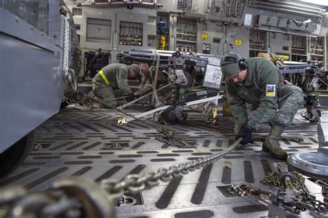 airmen tighten chains  secure cargo     globemaster iii aircraft  rapid raptor