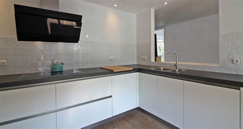 deze strakke mat witte keuken krijgt karakter door de mooie witte tegeltjes achterwand kitchen