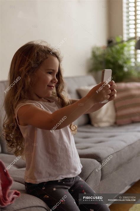 Cute Girl Taking Selfie With Mobile Phone In Living Room At Home — Stay