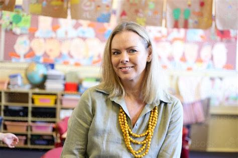 image of female teacher sitting in school classroom austockphoto