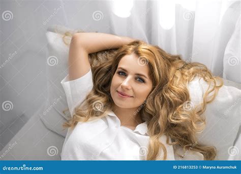 A Young Beautiful Woman Spread Her Curly Luxuriant Hair On A Pillow