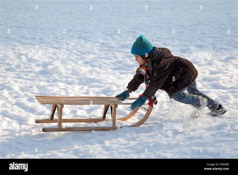 kleiner junge schlitten anstiege im schnee schieben stockfotografie alamy