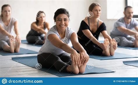 during yoga class group of people doing seated forward