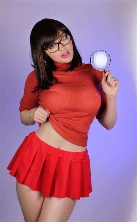 A Woman With Glasses Holding A Magnifying Glass In One Hand And Wearing