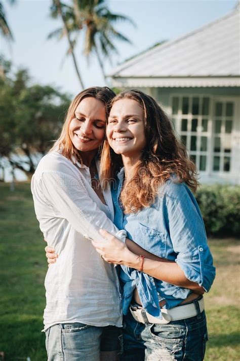 Happy Lesbian Couple Hugging In The Garden At Their Country House Stock