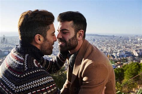gay men romancing while sitting against cityscape bunkers del carmel