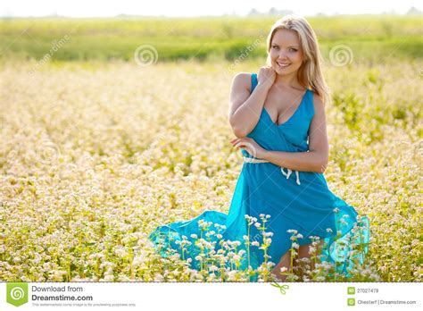 smiling woman wearing blue dress on a field stock image