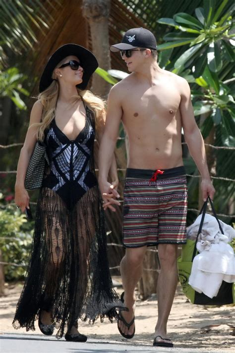 paris hilton wearing a swimsuit a see through lace dress on a beach in