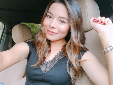 Miranda Cosgrove Sitting In Her Car On A Parking Lot And Looking For