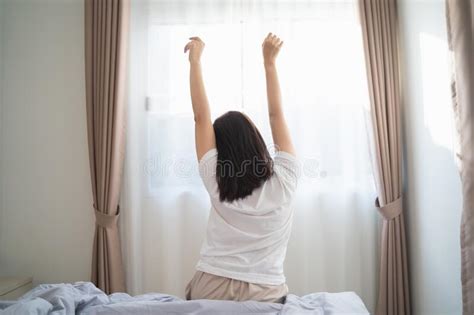 Asian Woman Stretching In The Bedroom After Wake Up Back View Stock