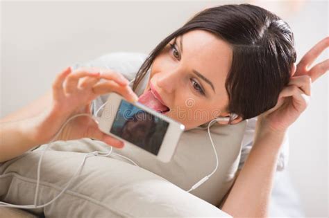 Young Woman Lying On The Floor Taking Pictures And Selfies Stock Image