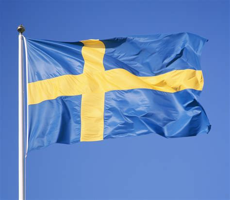 A Blue And Yellow Flag Flying High In The Sky With A Cross On Its Side