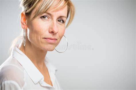 Portrait Of A Smiling Middle Aged Caucasian Woman Against Dark