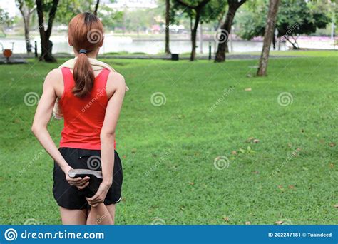 Healthy Asian Woman Stretching Her Legs Before Run In Park Fitness And