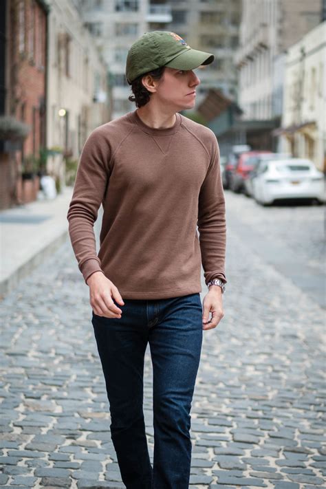 brown sweater  blue jeans  modest man