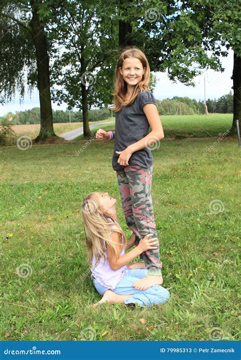 Two Girls Playing And Standing On Each Other Stock Image Image Of