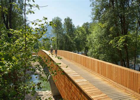 architects create beautiful arched footbridge   timber planks  shingles