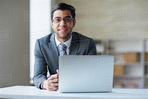 portrait  manager sitting   table  smiling  camera stock photo dissolve